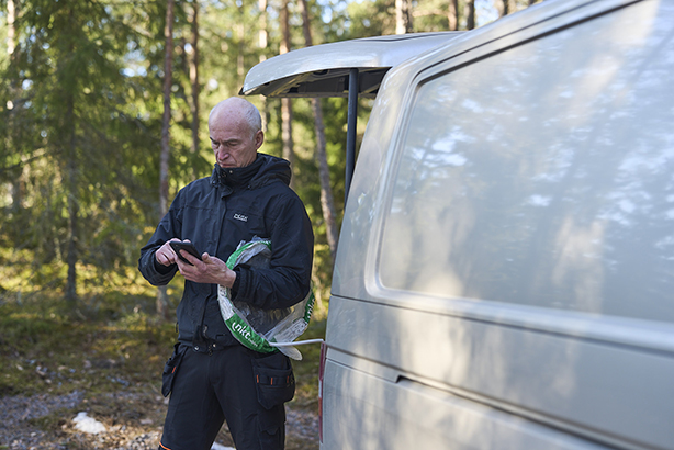 Sähkömies käyttää puhelimellaan Ecom Jetiä